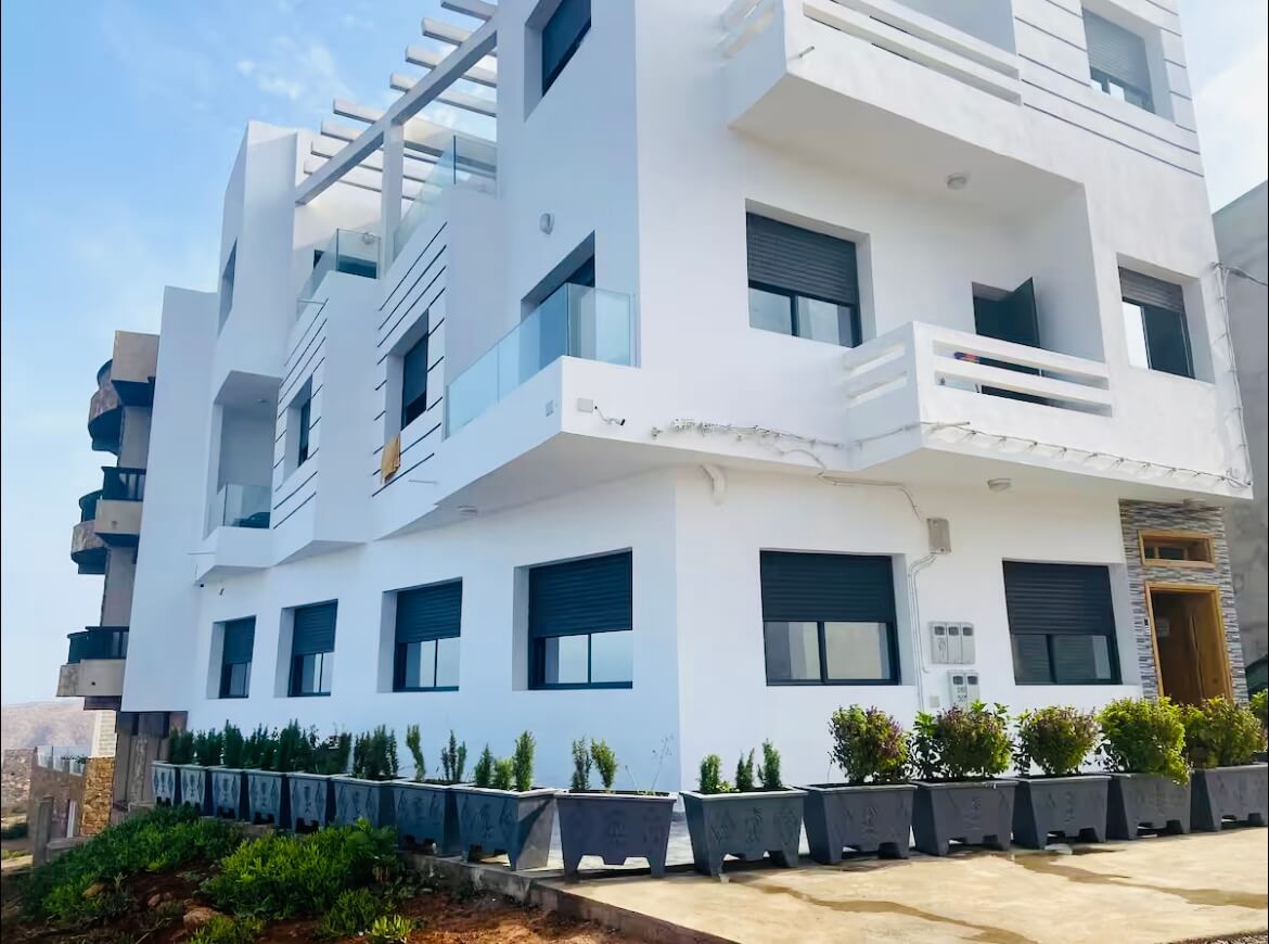 Résidence Amouage — biały budynek z balkonami nad Oceanem Atlantyckim w Mirleft, Maroko