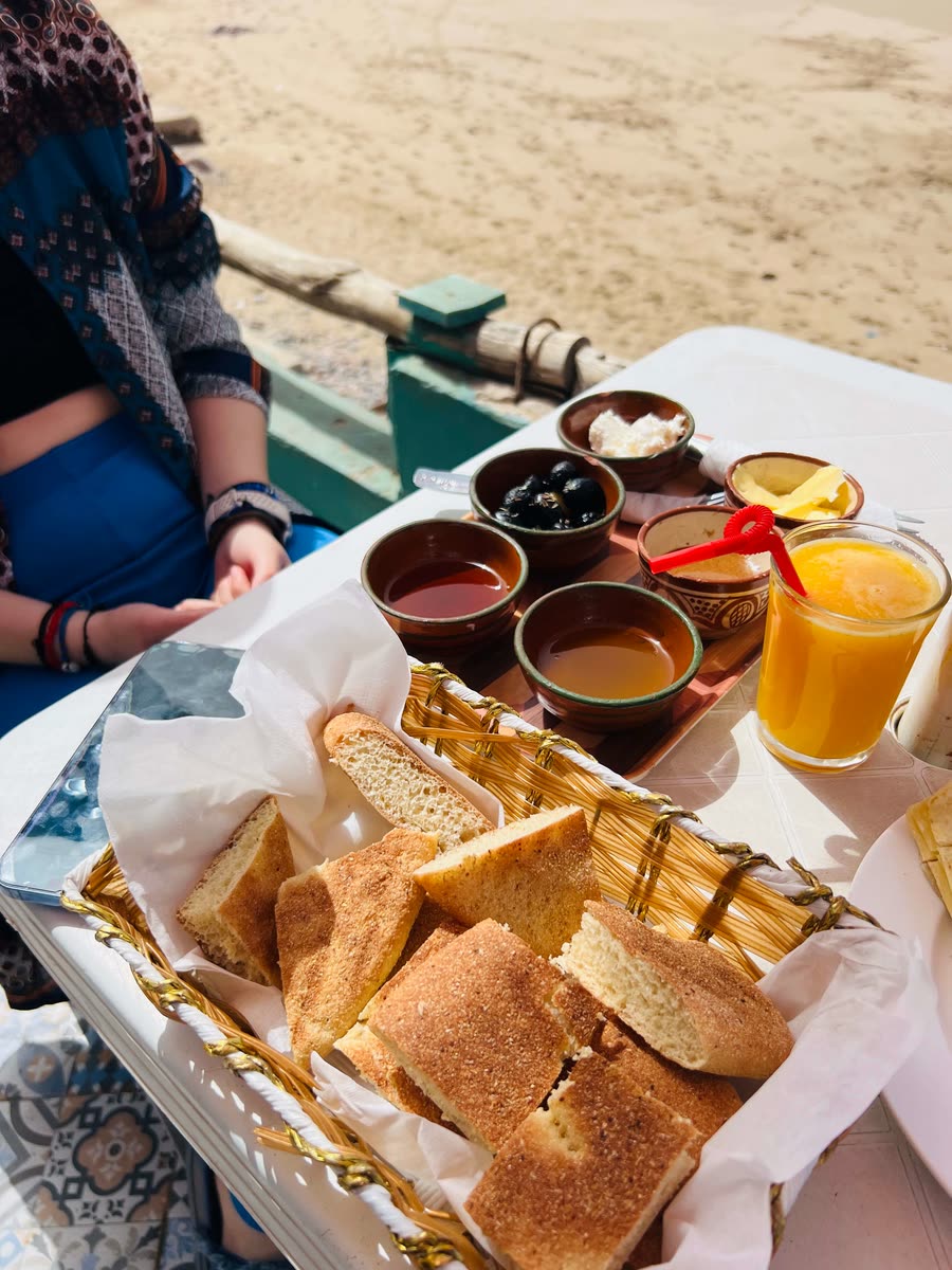 Moroccan breakfast with bread, honey, argan oil and fresh orange juice at a Mirleft beach café